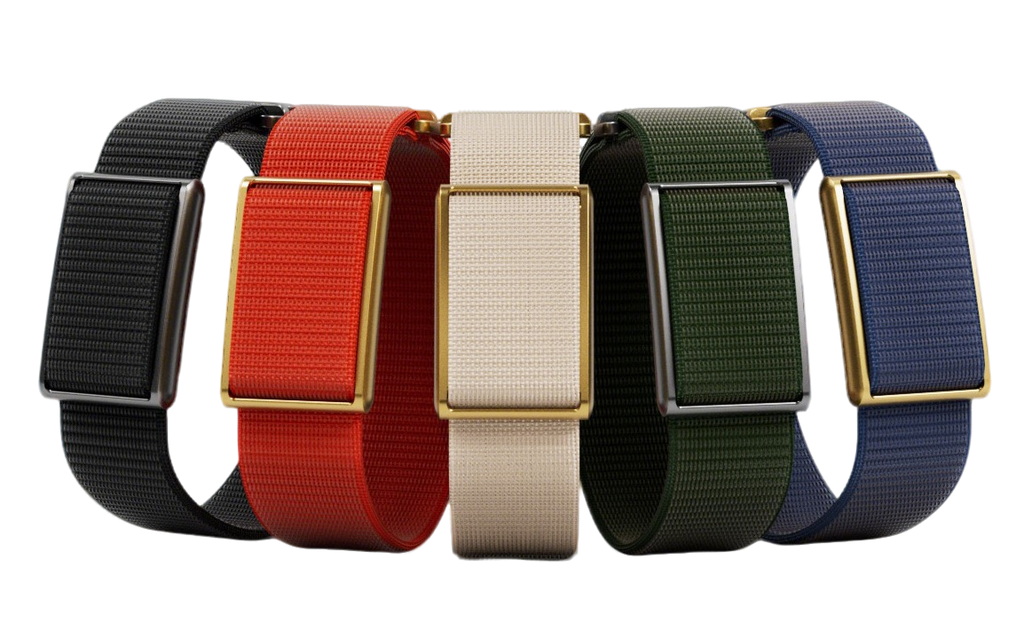 Four woven fabric watch straps in black, red, cream, and green, paired with rectangular gold-tone metal cases, arranged side by side on a white background.
